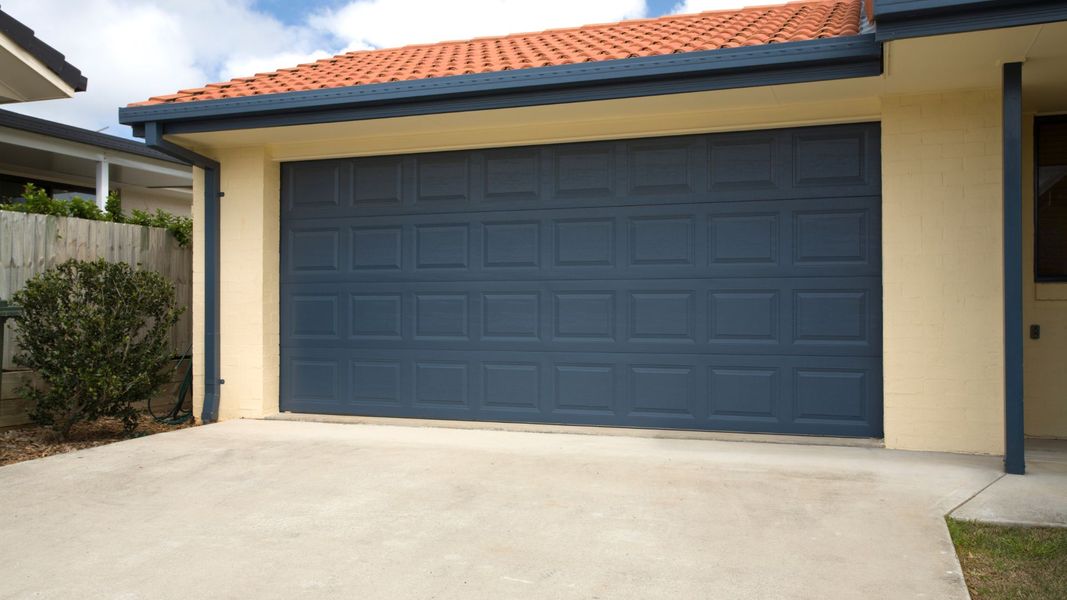 A white building with a blue door and a blue door. showcasing features like garage door services garage door repair garage door installation garage door spring repair new garage doors.