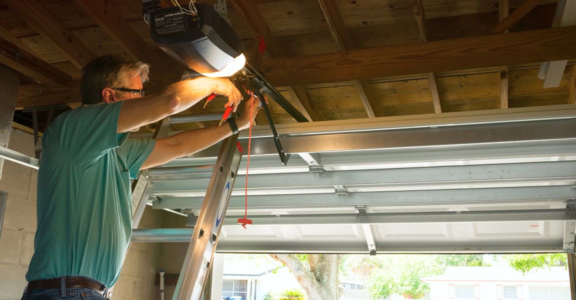 This scene from Lakewood, CO shows a man is fixing a pipe in a room. with features such as garage door services garage door repair garage door installation garage door spring repair.