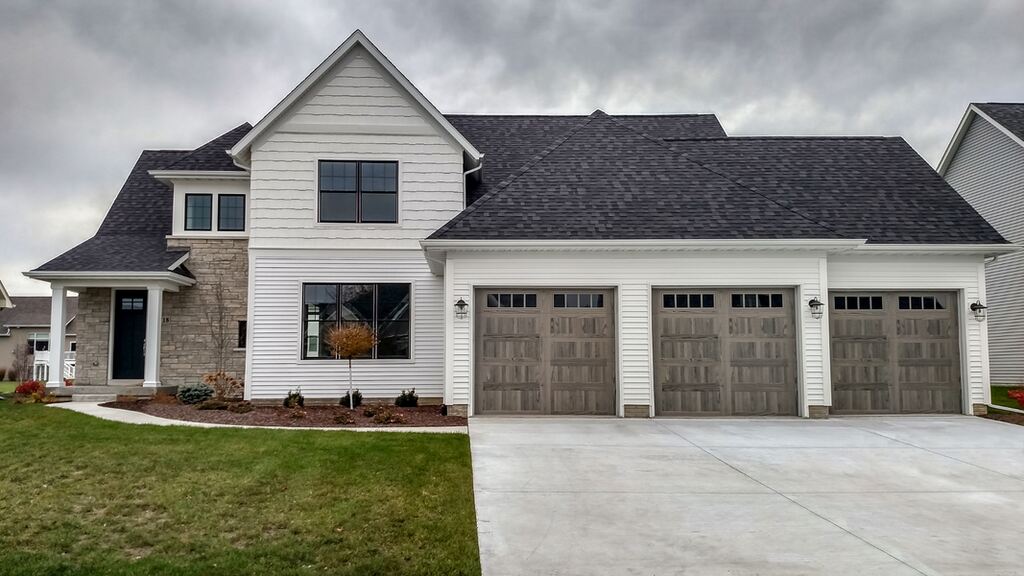 A house with a large window and a large building. showcasing features like garage door services garage door repair garage door installation garage door spring repair.