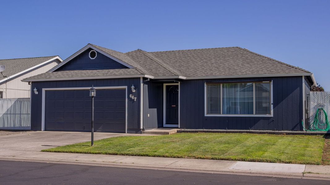 a house with a blue roof and a white house. features garage door services garage door repair garage door installation garage door spring repair provided by Retrak Door Service.