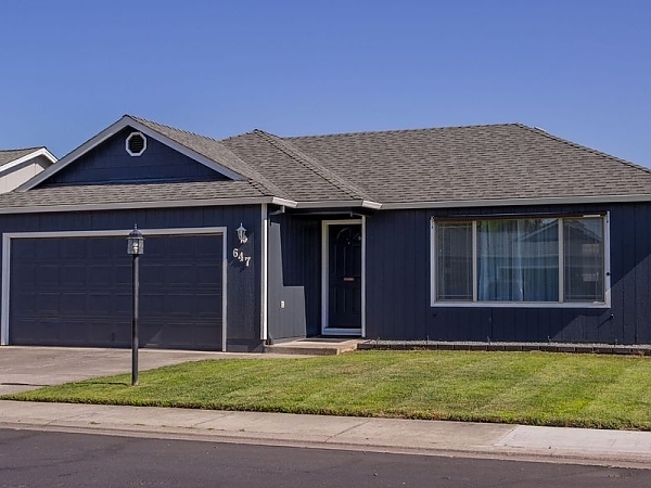 a house with a blue roof and a white house. features garage door services garage door repair garage door installation garage door spring repair provided by Retrak Door Service.