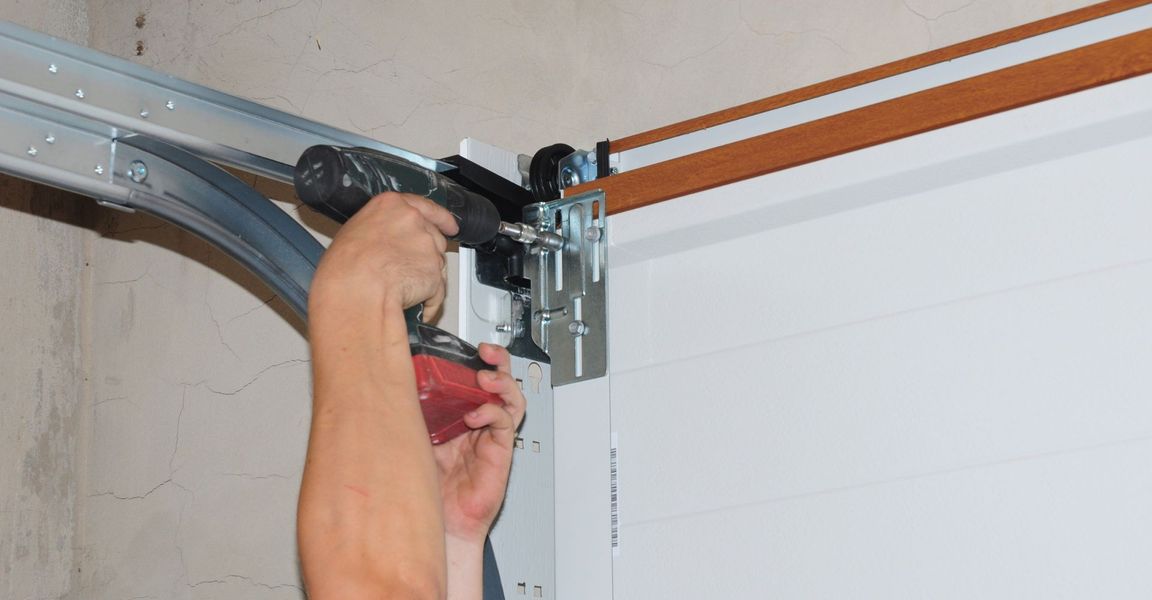 This scene from Lakewood, CO shows a man is holding a hose on a wall. with features such as garage door services garage door repair garage door installation garage door spring repair.