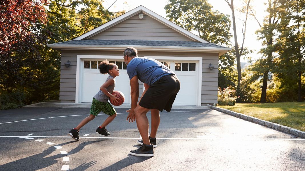 a man and a woman playing a game of basketball. features garage door services garage door repair garage door installation garage door spring repair provided by Retrak Door Service.