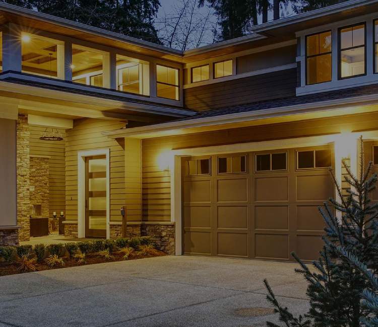 a house with a large window and a large tree. features garage door services garage door repair garage door installation garage door spring repair provided by Retrak Door Service.