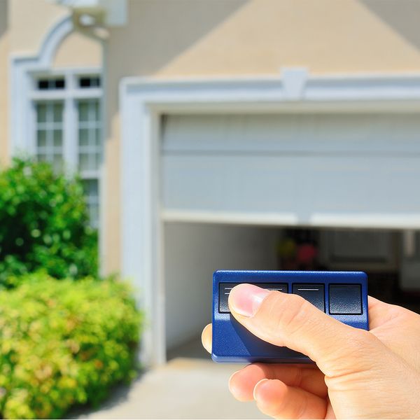 a person holding a cell phone in their hand. features garage door services garage door repair garage door installation garage door spring repair provided by Retrak Door Service.