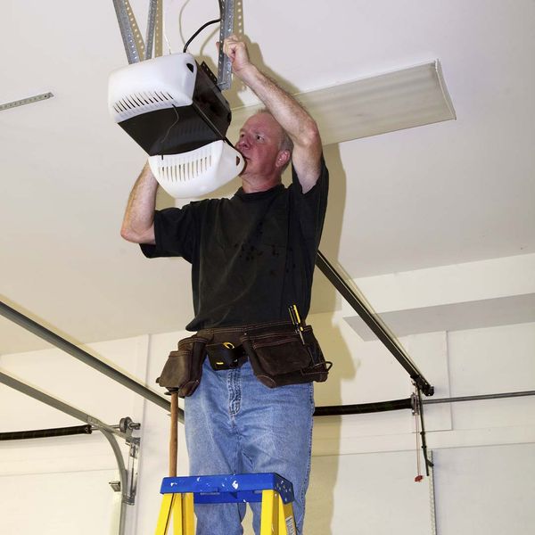 a man is holding a rope over his head. features garage door services garage door repair garage door installation garage door spring repair provided by Retrak Door Service.