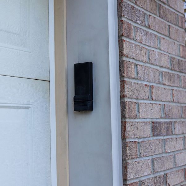 This scene from Lakewood, CO shows a telephone pole is next to a brick wall. with features such as garage door services garage door repair garage door installation garage door spring repair.