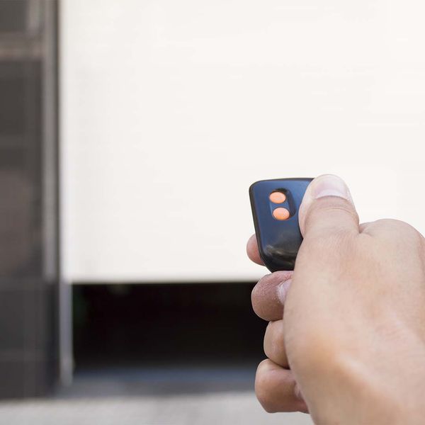 This scene from Lakewood, CO shows a person holding a cell phone in their hand. with features such as garage door services garage door repair garage door installation garage door spring repair.