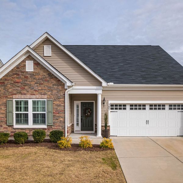 A house with a large window and a large brick building. showcasing features like garage door services garage door repair garage door installation garage door spring repair new garage doors.