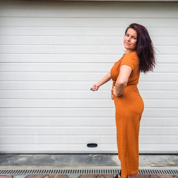 A woman in a pink dress standing in front of a building. showcasing features like garage door services garage door repair garage door installation garage door spring repair new garage doors.