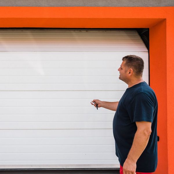 This scene from Lakewood, CO shows a man standing in front of a window holding a cell phone. with features such as garage door services garage door repair garage door installation garage door spring repair new garage doors.