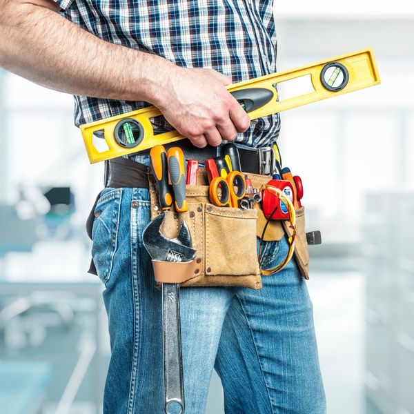 a man holding a pair of scissors next to a yellow object. features garage door services garage door repair garage door installation garage door spring repair new garage doors provided by Retrak Door Service.