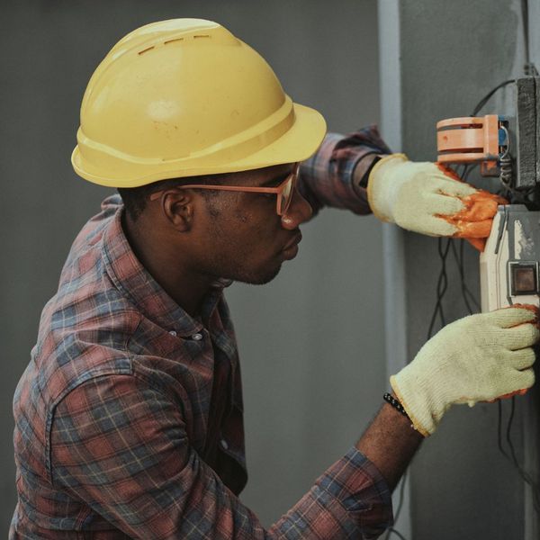 A man is fixing a broken electrical appliance. showcasing features like garage door services garage door repair garage door installation.