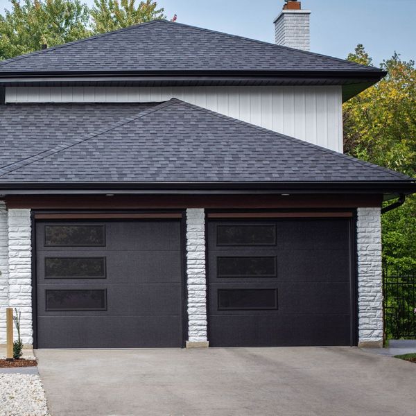 This scene from Lakewood, CO shows a house with a large window and a large brick building. with features such as garage door services garage door repair garage door installation garage door spring repair new garage doors.