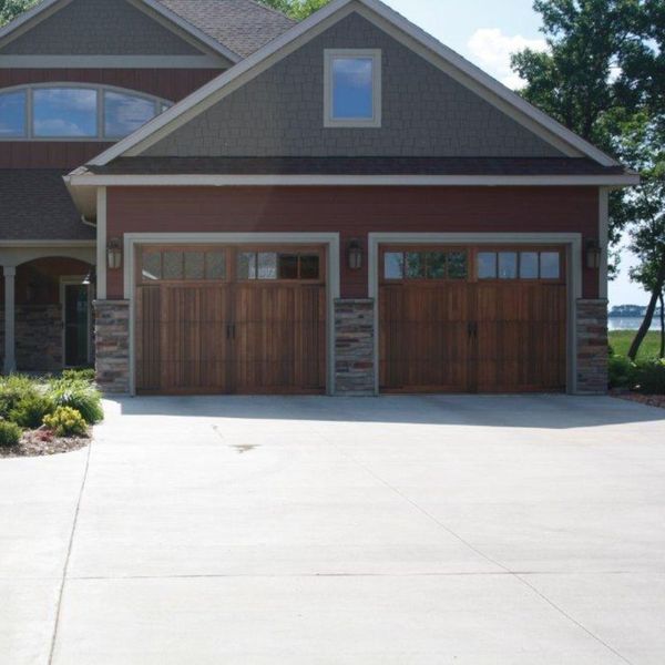 A large white house with a large window. showcasing features like garage door services garage door repair garage door installation.