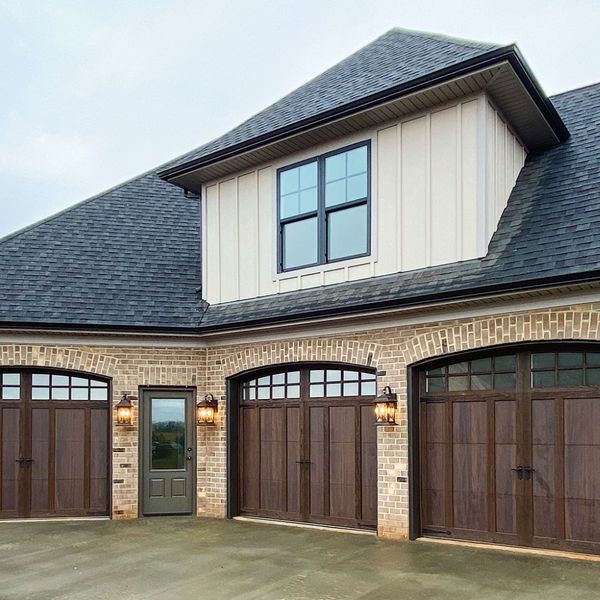 A large white house with a large window. showcasing features like garage door services garage door repair garage door installation.