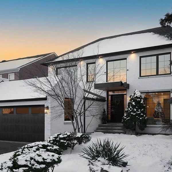 a house with a snow covered roof and a tree. features garage door services garage door repair garage door installation garage door spring repair provided by Retrak Door Service.