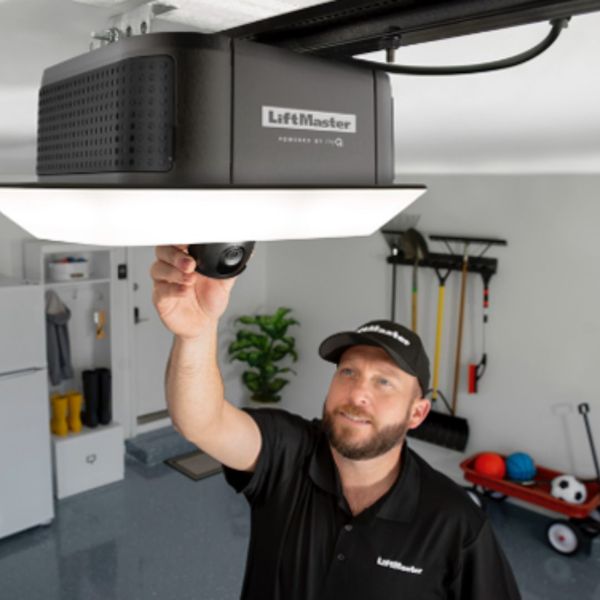 This scene from Lakewood, CO shows a man holding a remote control in front of a tv. with features such as garage door services garage door repair garage door installation garage door spring repair new garage doors.