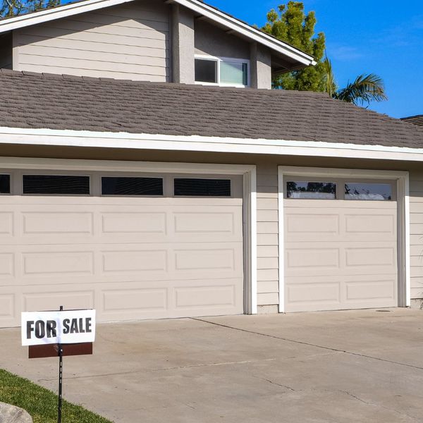 A white house with a blue door and a white house. showcasing features like garage door services garage door repair garage door installation garage door spring repair new garage doors.