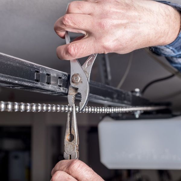 This scene from Lakewood, CO shows a man holding a pair of scissors in his hand. with features such as garage door services garage door repair garage door installation garage door spring repair.