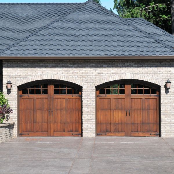 A large wooden door leading to a large white building. showcasing features like garage door services garage door repair garage door installation garage door spring repair.