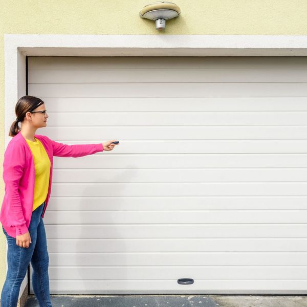 This scene from Lakewood, CO shows a woman standing in front of a door with a cell phone. with features such as garage door services garage door repair garage door installation garage door spring repair new garage doors.