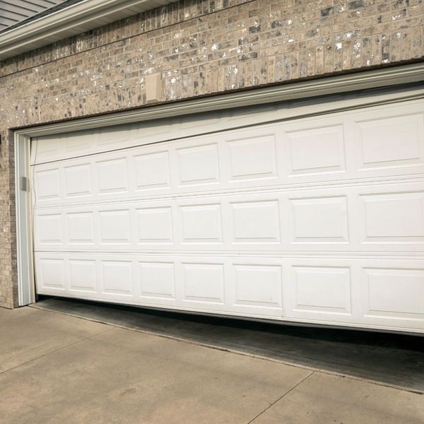 A white wall with a white door and a black door. showcasing features like garage door services garage door repair garage door installation garage door spring repair new garage doors.