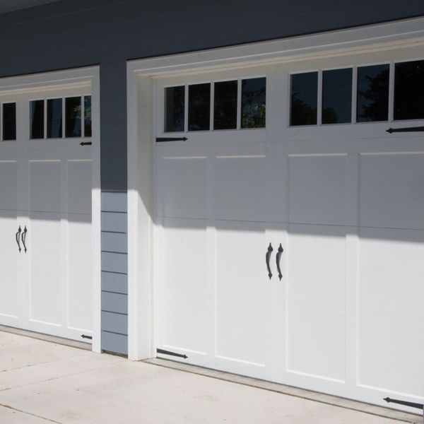 A white door leading to a building with a blue door. showcasing features like garage door services garage door repair garage door installation garage door spring repair new garage doors.