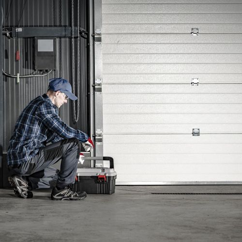 A man in a hat is sitting on a bench. showcasing features like garage door services garage door repair garage door installation garage door spring repair.