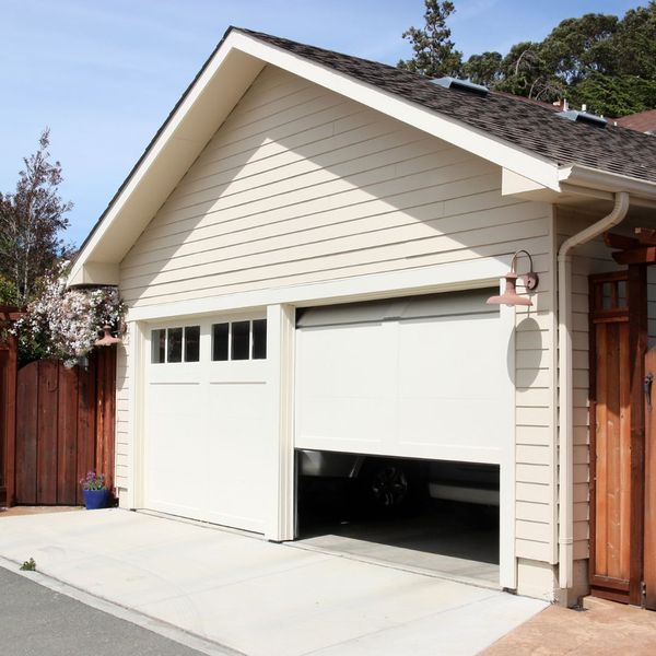 This scene from Lakewood, CO shows a white house with a white door and a black and white fire hydrant. with features such as garage door services garage door repair garage door installation garage door spring repair new garage doors emergency garage door service.