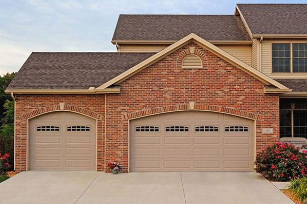 A house with a large brick building. showcasing features like garage door services garage door repair garage door installation.