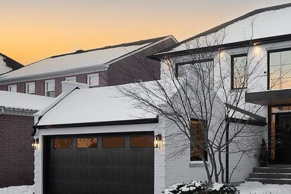 A house with a snow covered roof and a tree. showcasing features like garage door services garage door repair garage door installation garage door spring repair.
