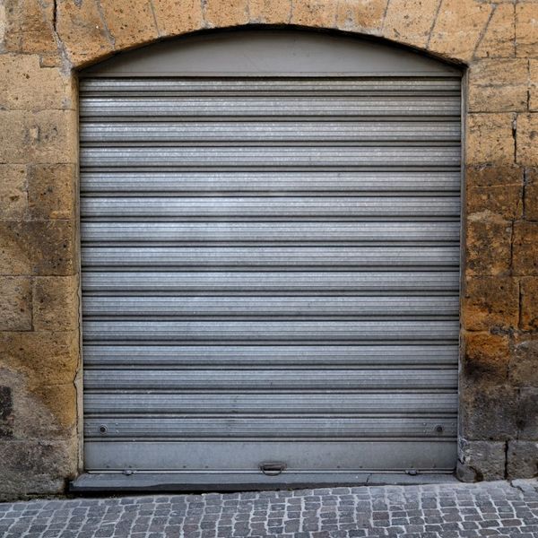 This scene from Lakewood, CO shows a stone wall with a door and a brick wall. with features such as garage door services garage door repair garage door installation garage door spring repair.