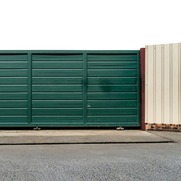 a green truck is parked on the side of the road. features garage door services garage door repair garage door installation garage door spring repair new garage doors provided by Retrak Door Service.