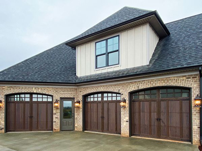 A large white house with a large window. showcasing features like garage door services garage door repair garage door installation.