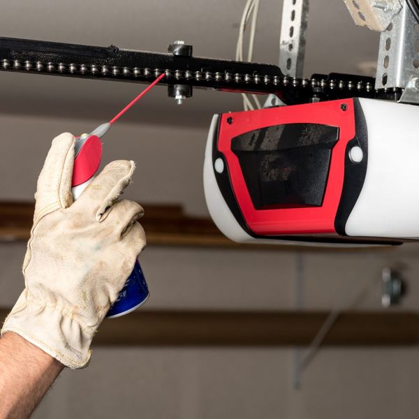 This scene from Lakewood, CO shows a man is holding a wrench and a pair of gloves. with features such as garage door services garage door repair garage door installation garage door spring repair new garage doors.