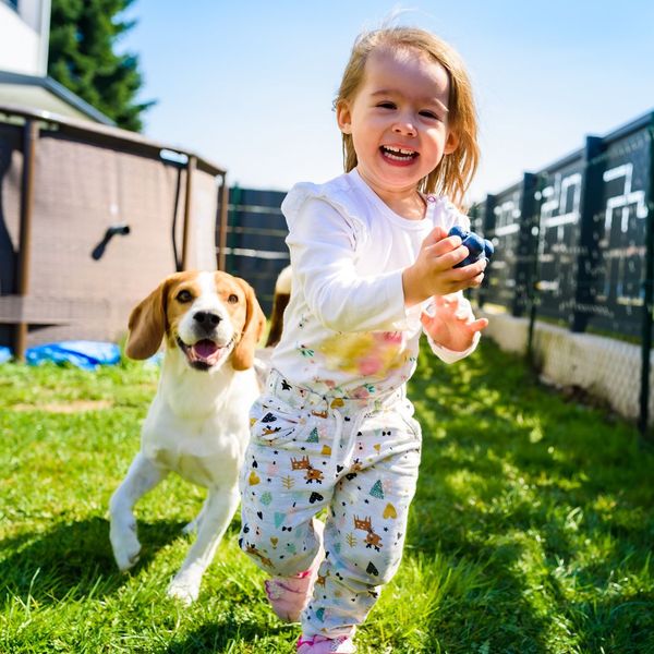 A little girl holding a dog in her arms. showcasing features like garage door services garage door repair garage door installation garage door spring repair.