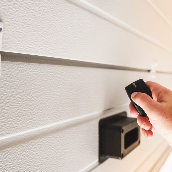 This scene from Lakewood, CO shows a person holding a cell phone in their hand. with features such as garage door services garage door repair garage door installation garage door spring repair.