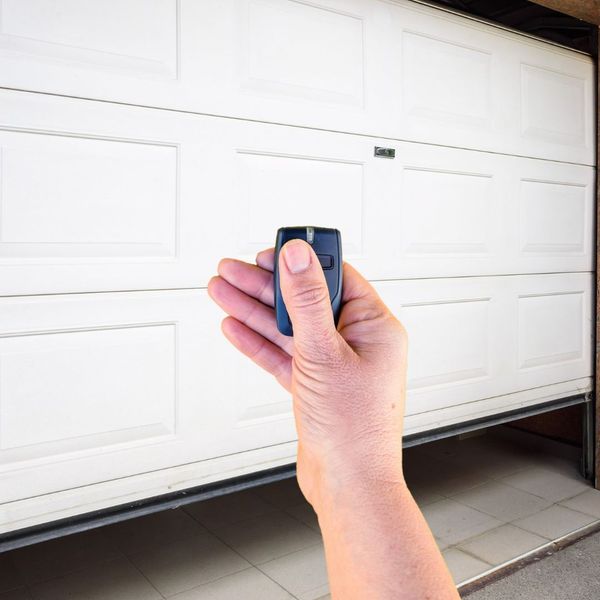 a person holding a cell phone in their hand. features garage door services garage door repair garage door installation garage door spring repair provided by Retrak Door Service.