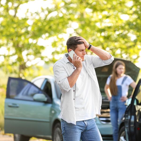 a man talking on a cell phone while standing in the grass. features garage door services garage door repair garage door installation garage door spring repair new garage doors provided by Retrak Door Service.