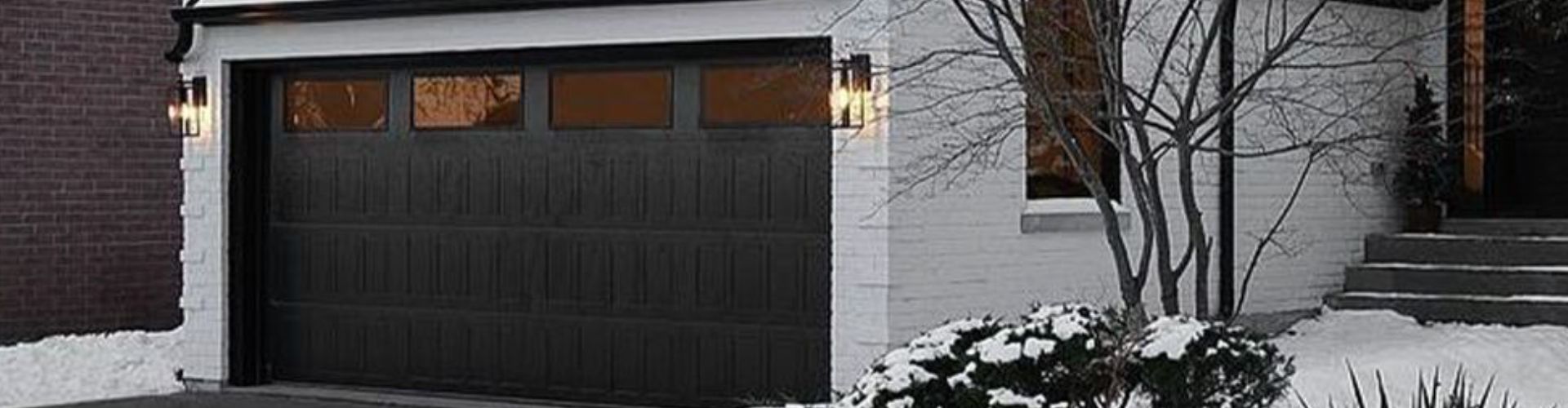 a white house with a blue door and a white fence. features garage door services garage door repair garage door installation garage door spring repair new garage doors provided by Retrak Door Service.