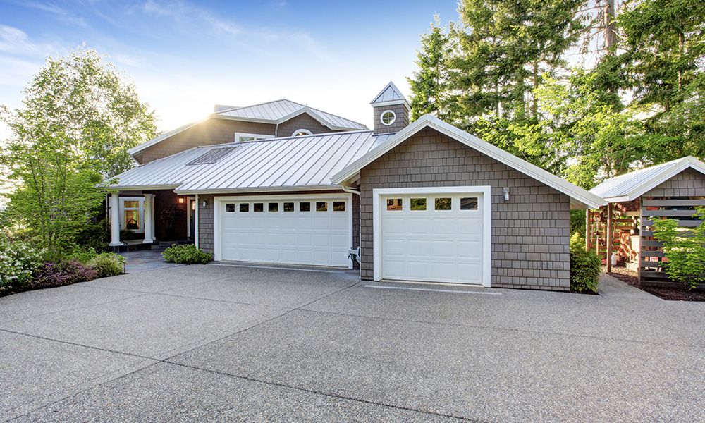 A white house with a white roof and a white house. showcasing features like garage door services garage door repair garage door installation garage door spring repair new garage doors.