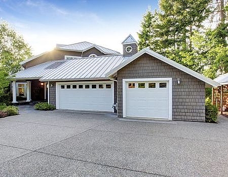 A white house with a white roof and a white house. showcasing features like garage door services garage door repair garage door installation garage door spring repair new garage doors.