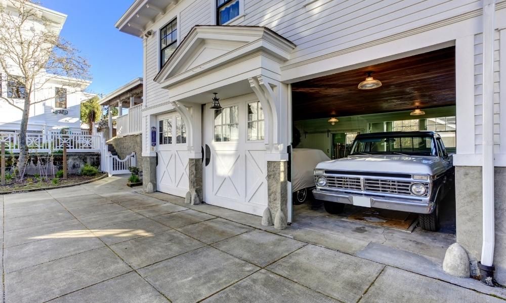 a white car parked in front of a white building. features garage door services garage door repair garage door installation garage door spring repair provided by Retrak Door Service.