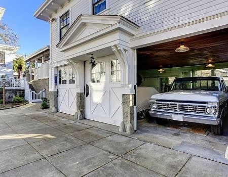 a white car parked in front of a white building. features garage door services garage door repair garage door installation garage door spring repair provided by Retrak Door Service.