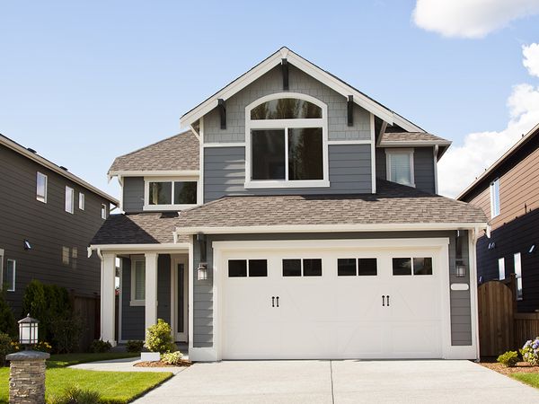 a white house with a white roof and a white house. features garage door services garage door repair garage door installation garage door spring repair new garage doors provided by Retrak Door Service.