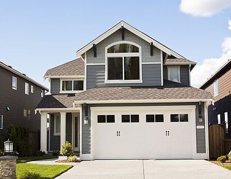 a white house with a white roof and a white house. features garage door services garage door repair garage door installation garage door spring repair new garage doors provided by Retrak Door Service.